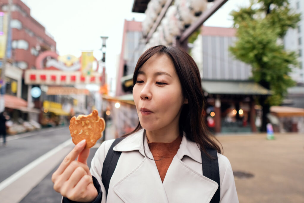 硬いせんべいを食べている女性