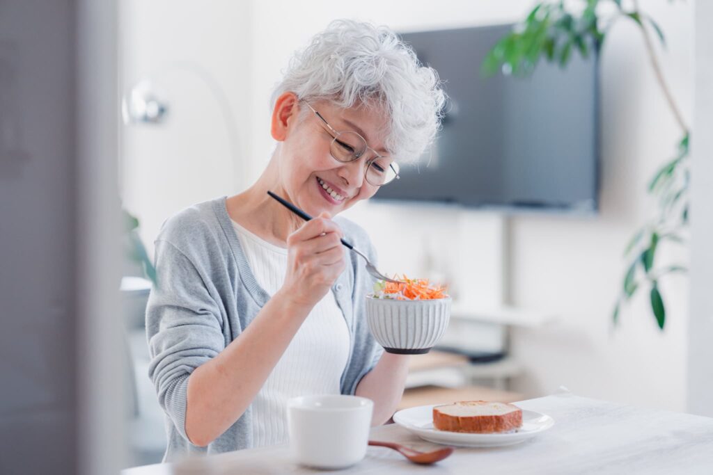 歯周病の治療をして美味しく食事を楽しむ老人