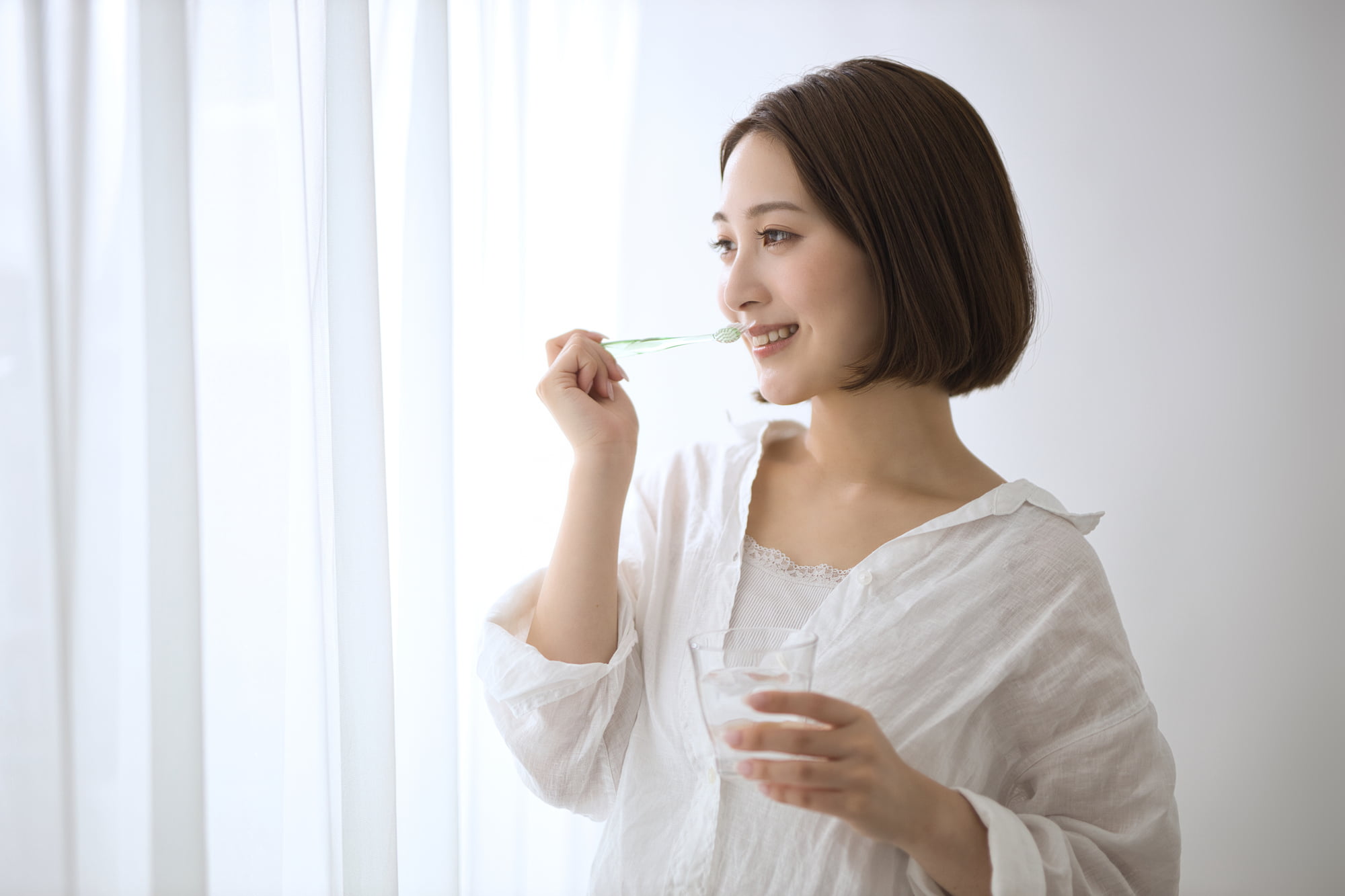 セラミックの歯を長く使うために丁寧に歯磨きをする女性