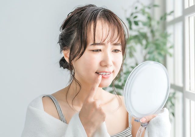 手鏡で歯を見ている女性
