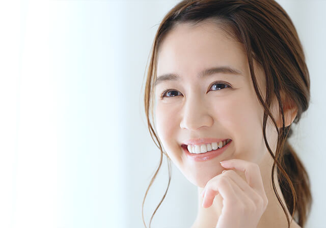 白い歯を見せて微笑んでいる女性